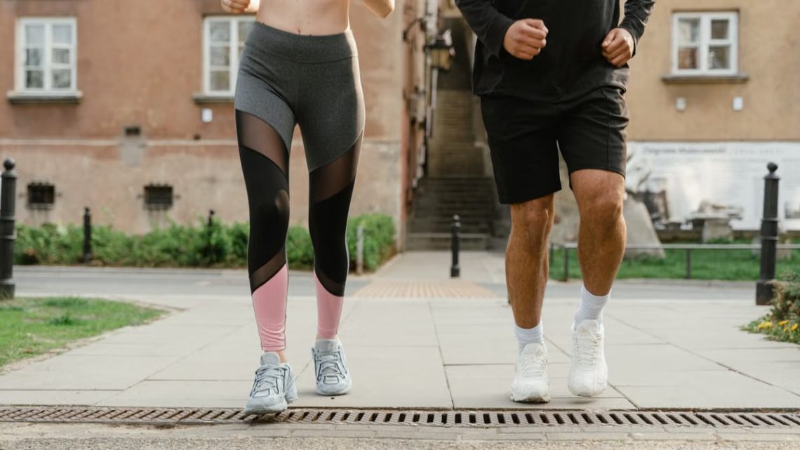 Two adults jogging outdoors, promoting health and fitness in an urban setting.