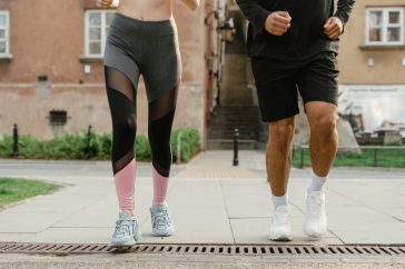 Two adults jogging outdoors, promoting health and fitness in an urban setting.
