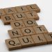 Close-up of Scrabble tiles forming the motivational phrase 'Fail but do not quit' on a white surface.